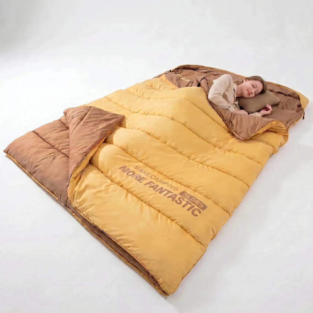 Cozy yellow & brown double sleeping bag for couples. Warm, insulated outdoor gear for camping, hiking, and winter travel.