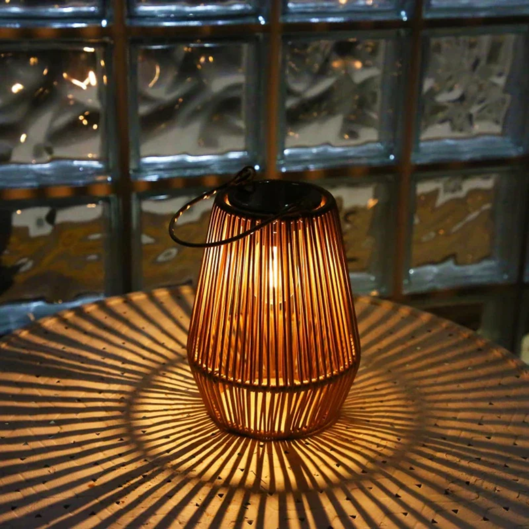 Compact waterproof solar garden light, rattan-look, providing ambient outdoor LED illumination.