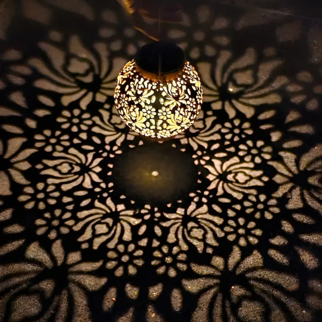 Decorative solar-powered LED hanging lantern illuminating a garden, an energy-saving outdoor accent light.