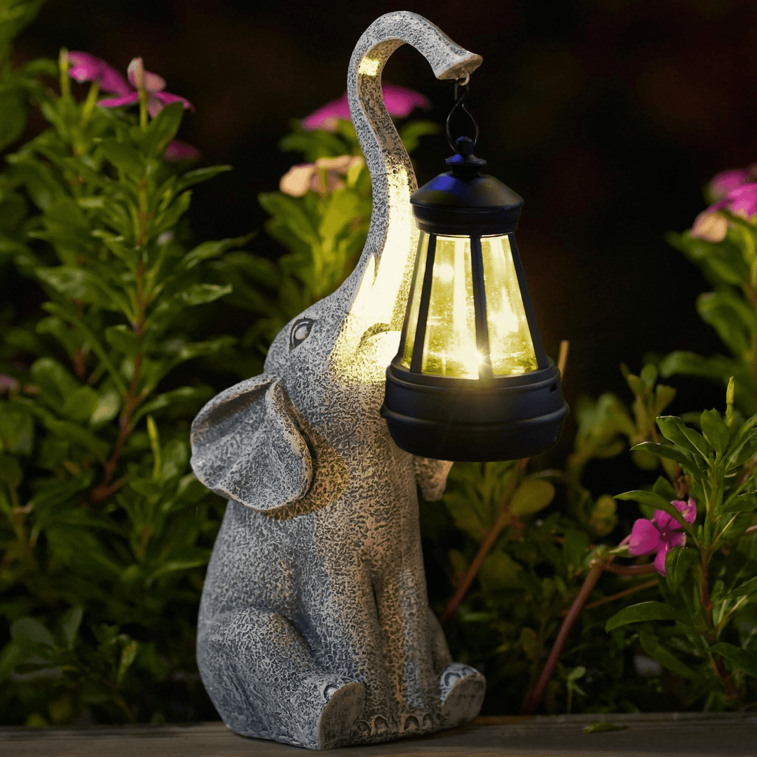 Whimsical elephant solar garden lamp. Resin statue providing ambient outdoor lighting for patio decor.