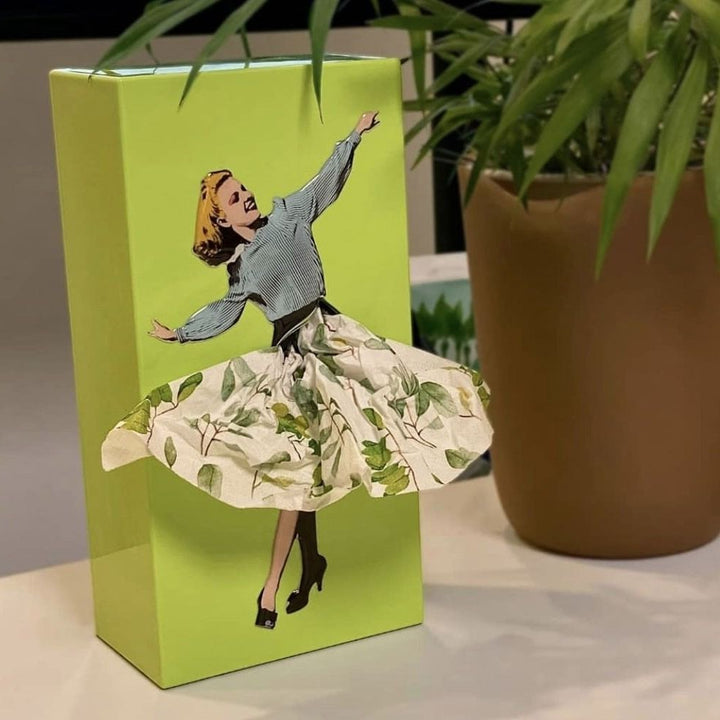 Interactive flying skirt tissue box in purple. Novelty tissue dispenser for bathroom or desk.
