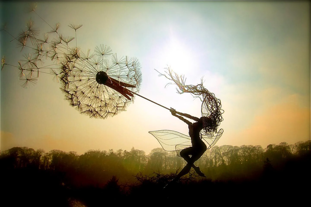 Naughty spirits dancing on a dandelion garden stake. Whimsical metal art for enchanting outdoor decor.