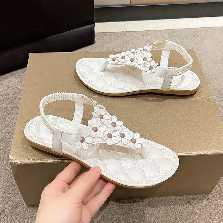 White women's sandals with delicate floral designs, offering stylish comfort for summer outings and events.