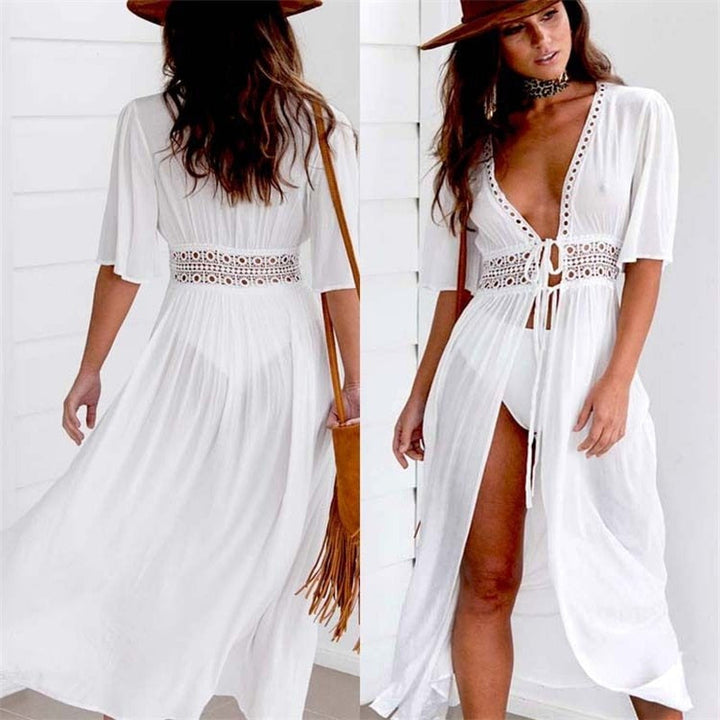 White women's long beach dress with delicate lace details and an elegant bow tie closure. Perfect for summer resort wear.