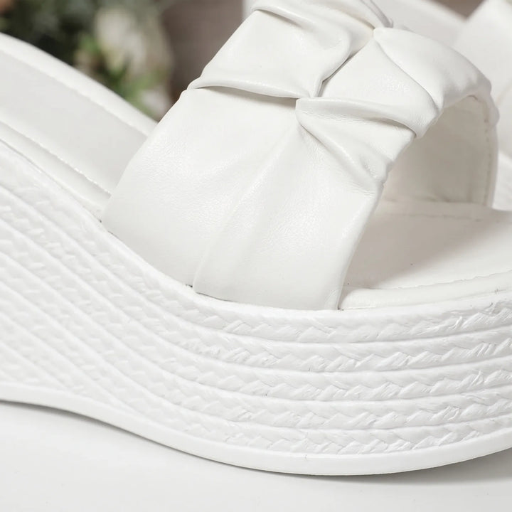 Comfortable women's slip-on sandals featuring a chunky white platform wedge heel & open toe for summer style.