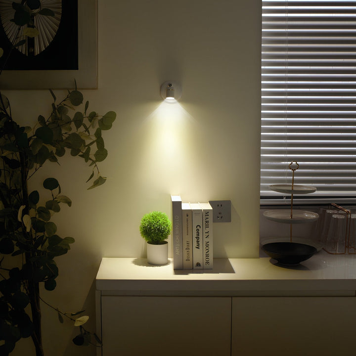 Dimmable LumaSpot LED spotlight casting a warm glow on a bookshelf at home.