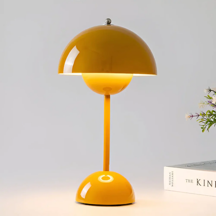 Ambient lighting created by the adjustable LED wireless portable table lamp on a nightstand.