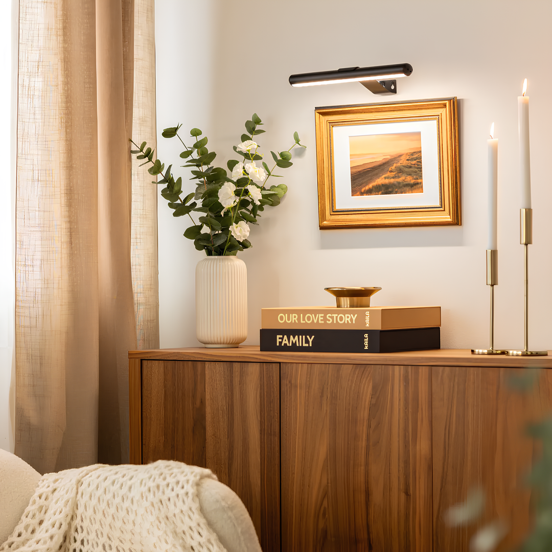 Wireless rechargeable LED picture light illuminating a framed artwork, perfect for home decor