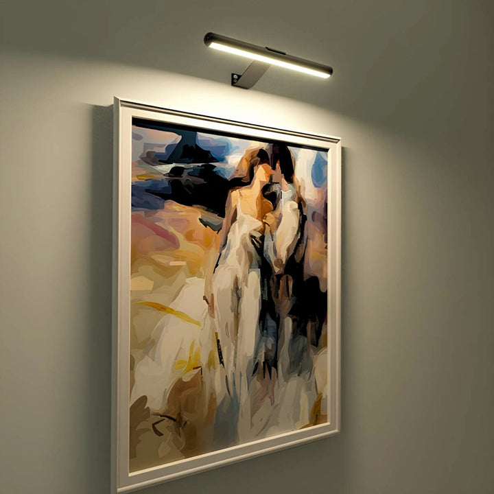 Rechargeable LED art lighting fixture mounted above a painting, offering warm illumination