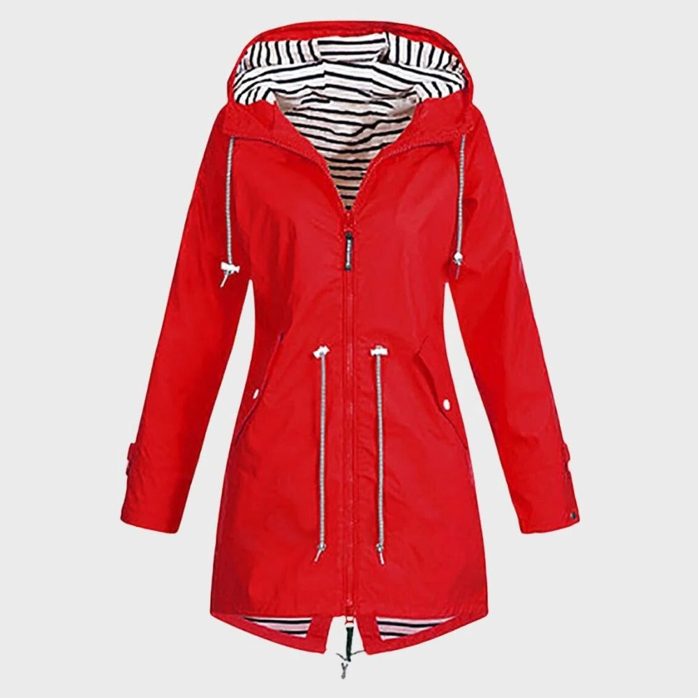 Woman wearing a stylish long waterproof rain jacket with hood. Perfect for weather protection & outdoor fashion.