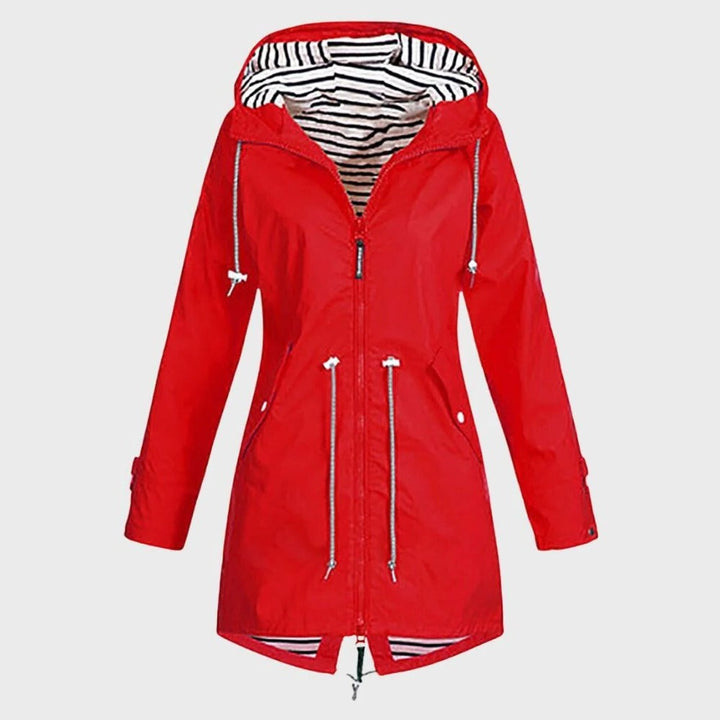 Woman wearing a stylish long waterproof rain jacket with hood. Perfect for weather protection & outdoor fashion.