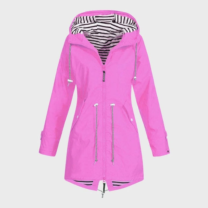 Elegant woman walking in a breathable long rain jacket, offering stylish outerwear for spring & fall weather.