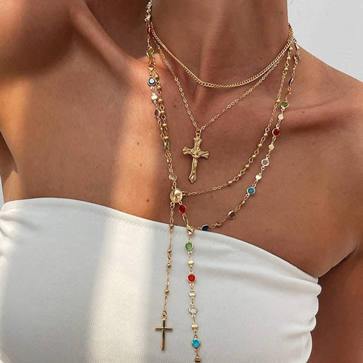 Women's 4-piece layered cross necklace set with mixed metals & pendants, a versatile fashion accessory.