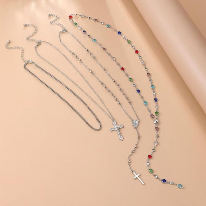 Fashionable 4-piece layered cross pendant necklace set, ideal religious jewelry for women with crystal details.