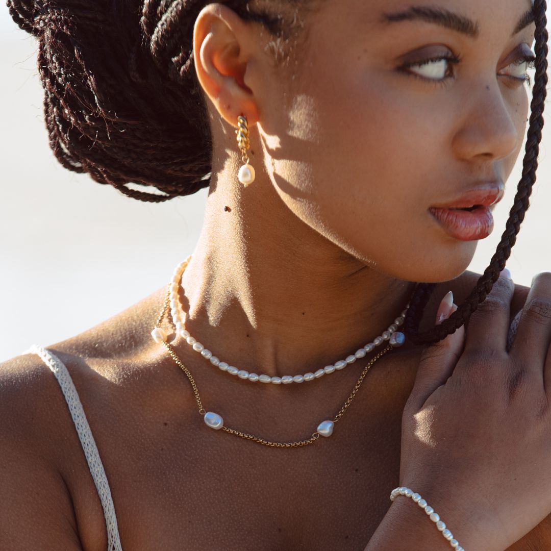 Delicate adjustable freshwater pearl choker necklace for women, elegant gold jewelry, styled with pearls.