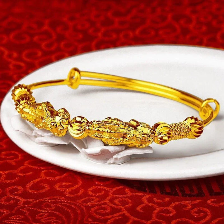 Close-up of a women's adjustable gold good luck charm bracelet, showcasing the intricate charm.