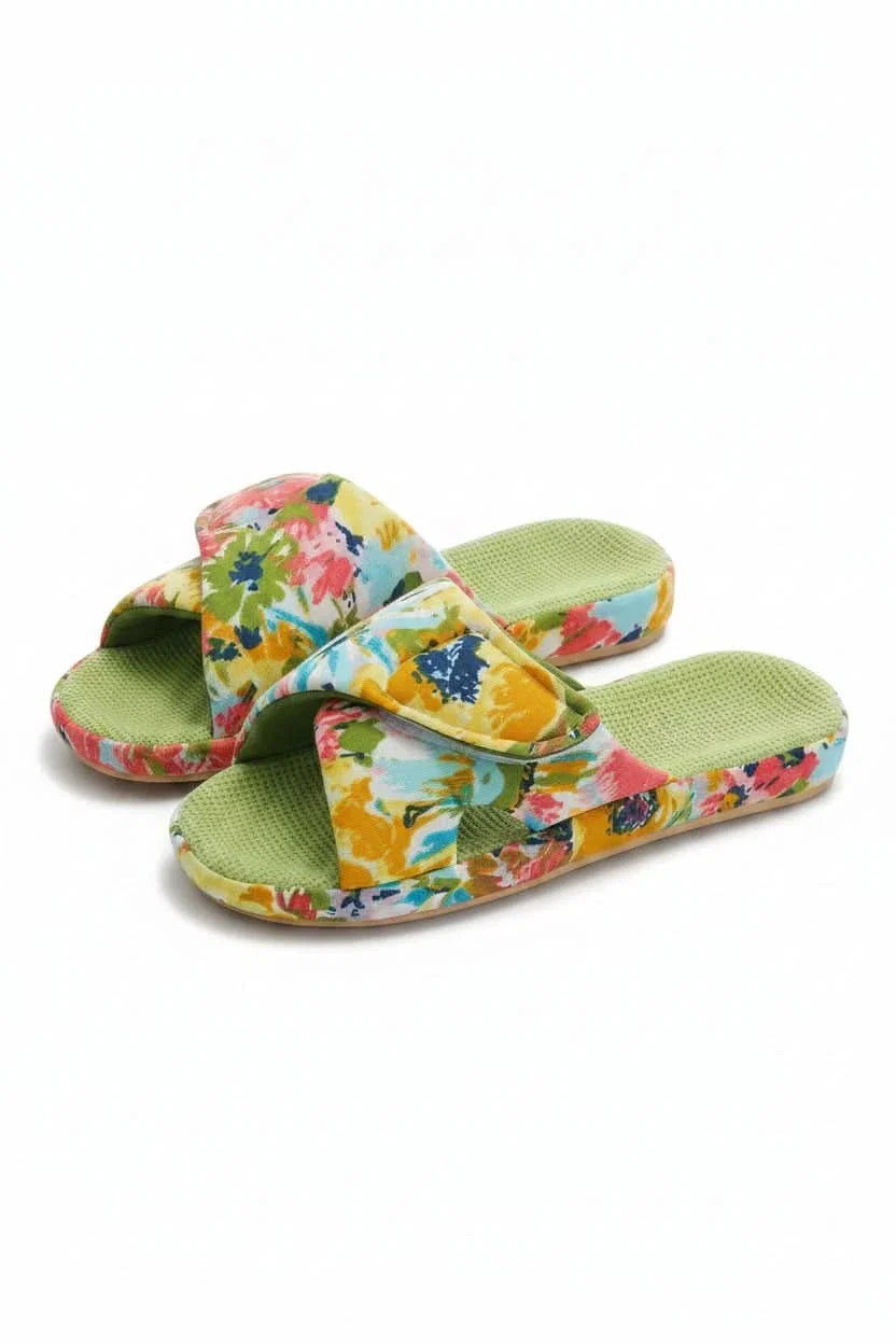 View of women's adjustable open toe comfort slippers on a wooden floor, ready for cozy wear.