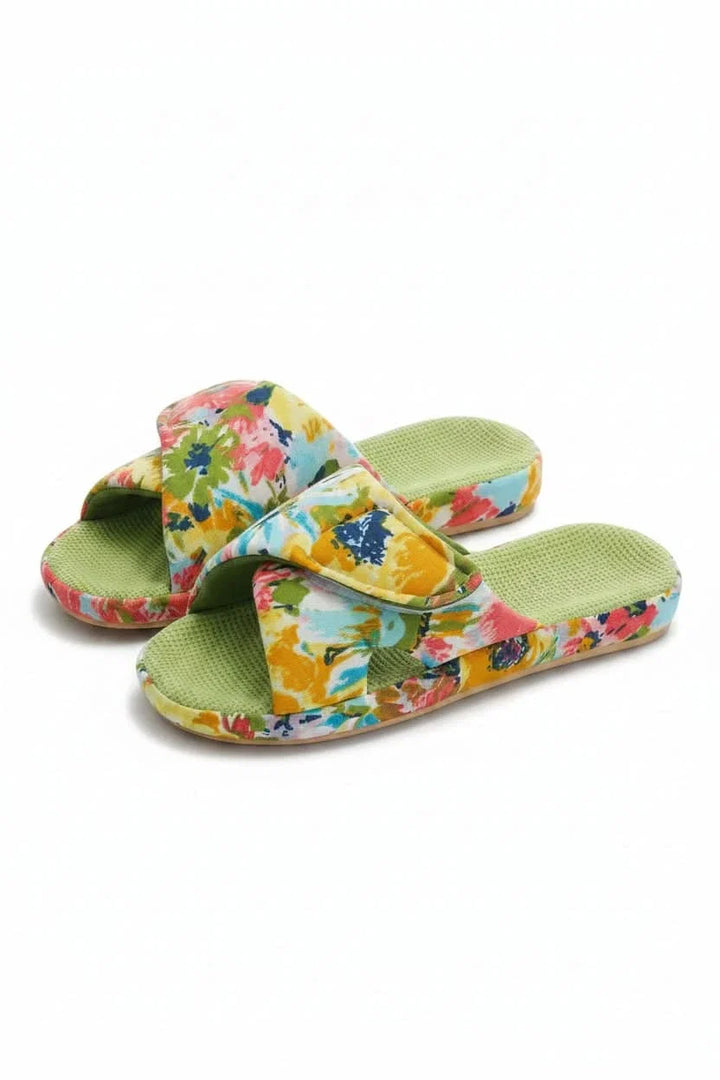 View of women's adjustable open toe comfort slippers on a wooden floor, ready for cozy wear.