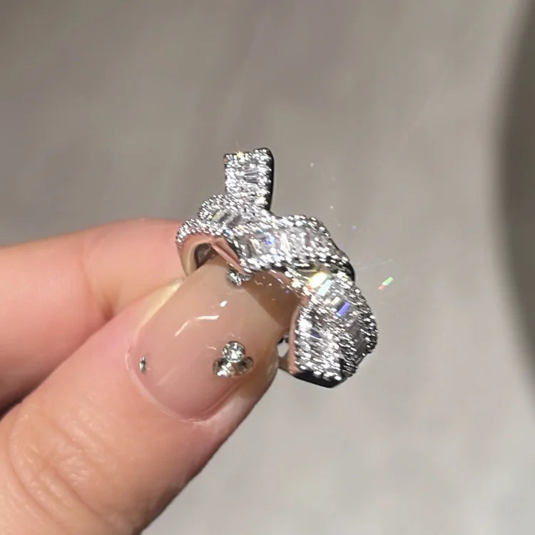 Close-up of an elegant adjustable gold knot ring for women, featuring brilliant zirconia stones. Perfect gift.