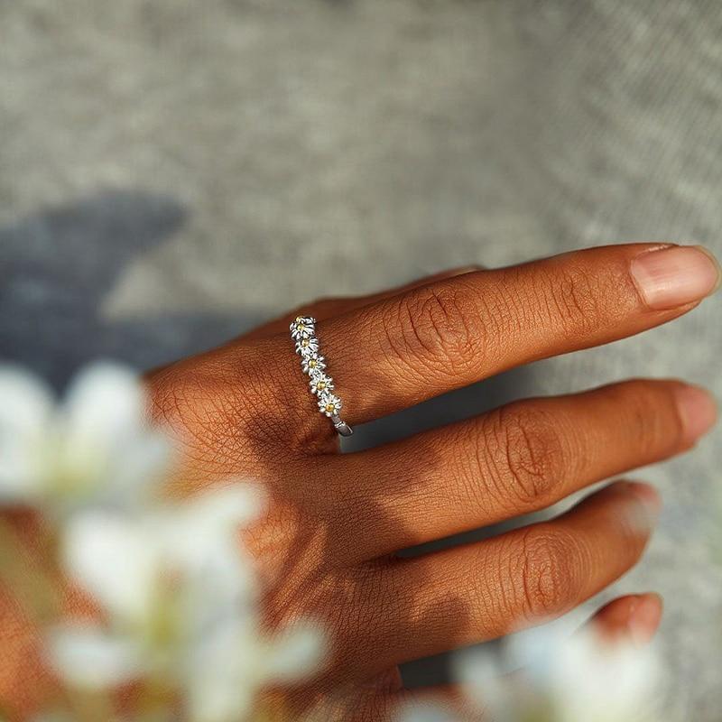 Elegant adjustable silver ring for women featuring a detailed white enamel daisy; a unique handmade floral statement piece.