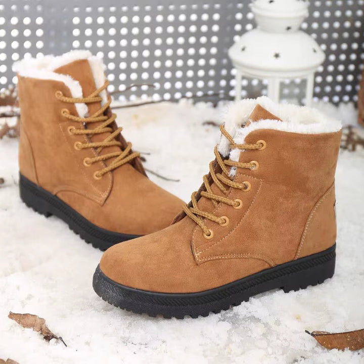 Woman walking in snow wearing cozy Aspen plush winter boots, showcasing style and cold-weather performance.