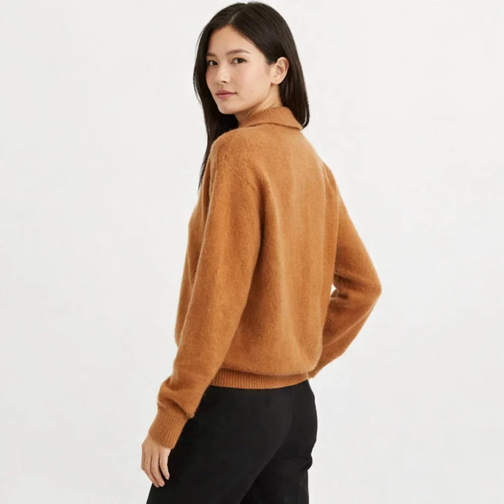 Detail shot of the unique asymmetrical button placket on a stylish women's knit cardigan.