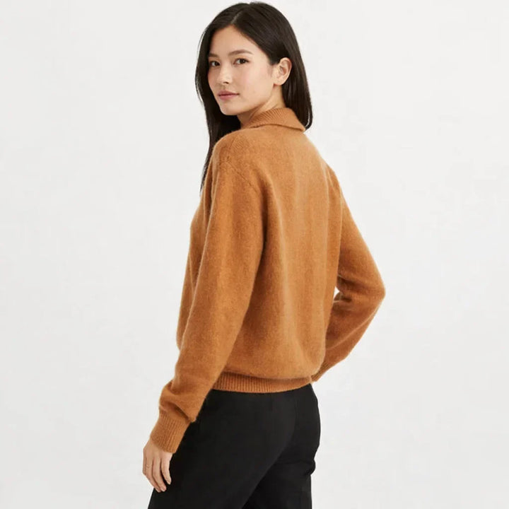 Detail shot of the unique asymmetrical button placket on a stylish women's knit cardigan.
