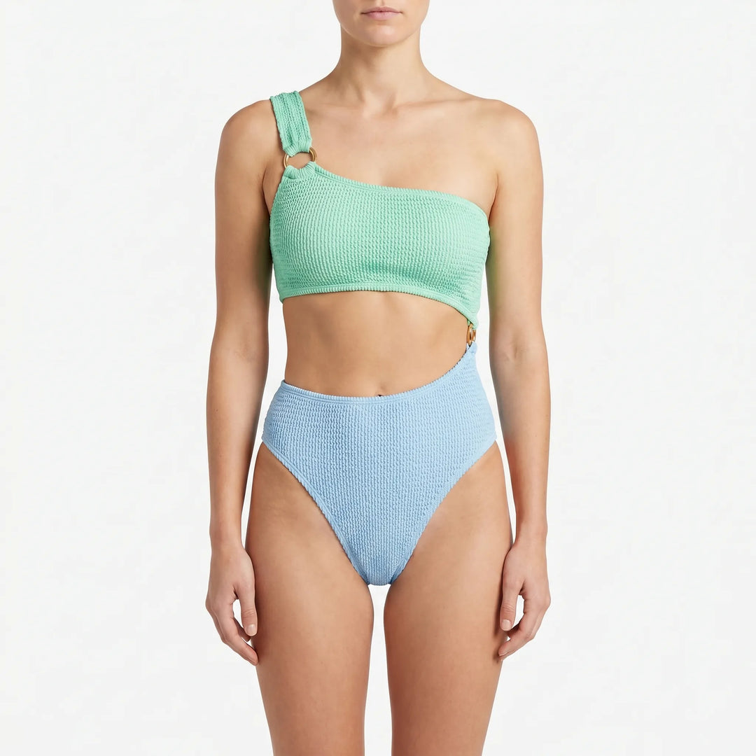 Fashionable women's asymmetric monokini swimsuit featuring bold cut-outs & gold ring detail. Perfect for vacation.