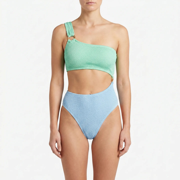 Fashionable women's asymmetric monokini swimsuit featuring bold cut-outs & gold ring detail. Perfect for vacation.