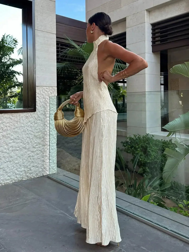 Stylish women's pleated two-piece set with a halter neck top & wide-leg pants, perfect for summer fashion.