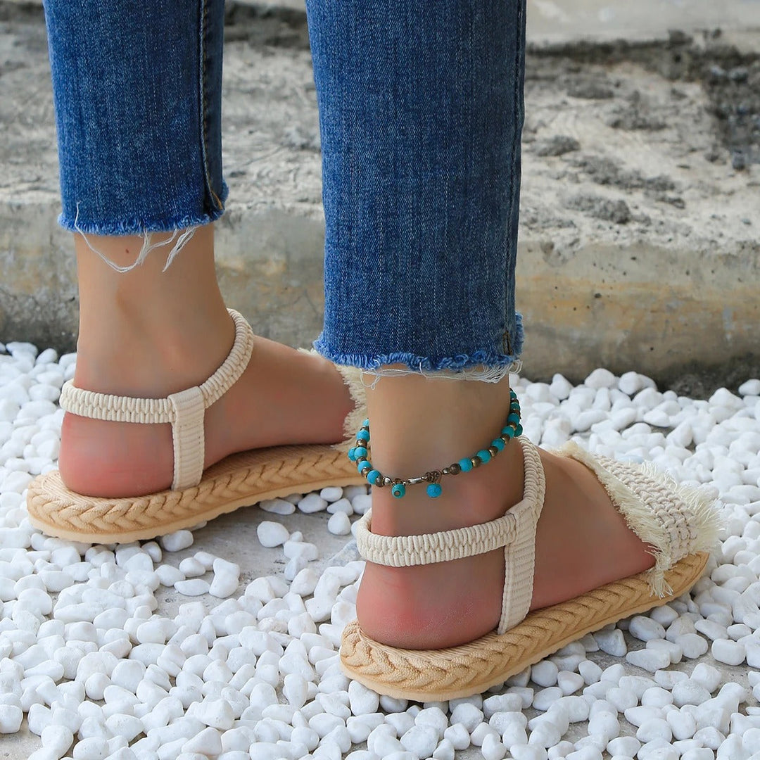 Trendy women's summer sandals: low heel, tassel accents, and elegant lace-up closure.