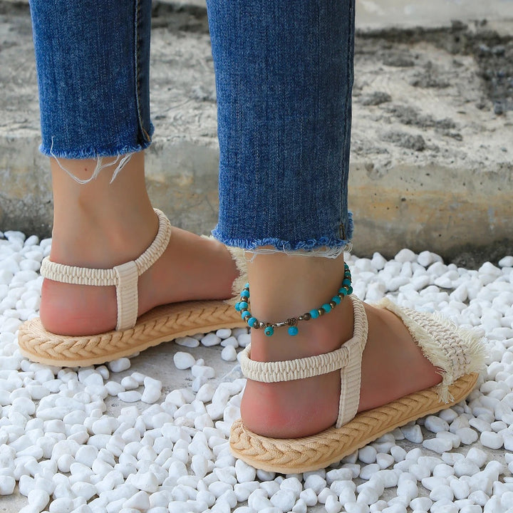 Trendy women's summer sandals: low heel, tassel accents, and elegant lace-up closure.