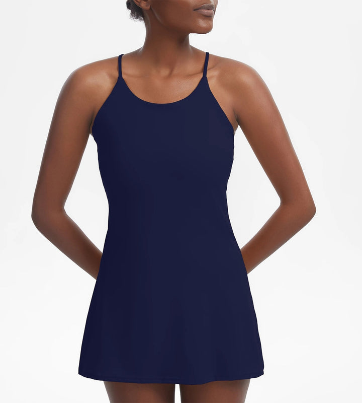 Model wearing a pink women's active sports dress, showcasing the built-in shorts and functional pockets.