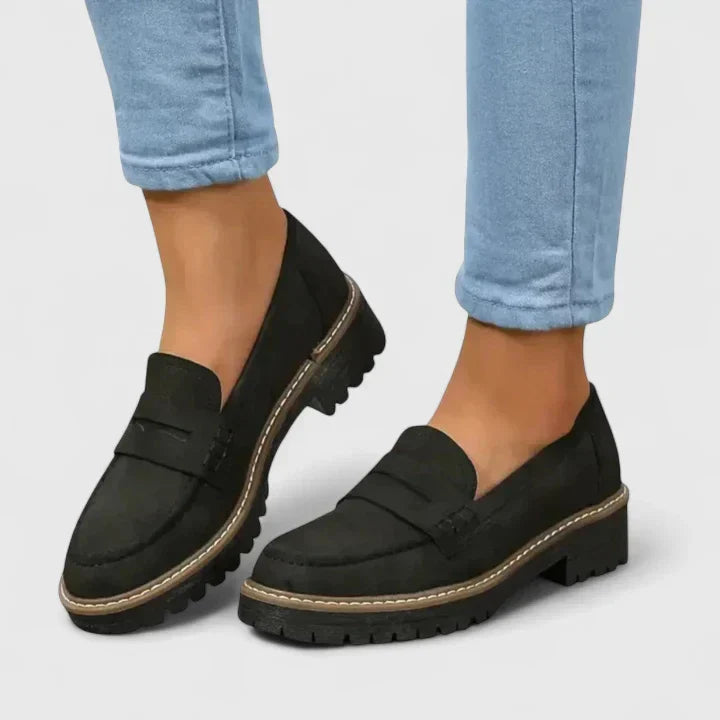 Women's black chunky lug-sole penny loafers with platform for preppy style. Stylish and comfortable slip-on footwear.