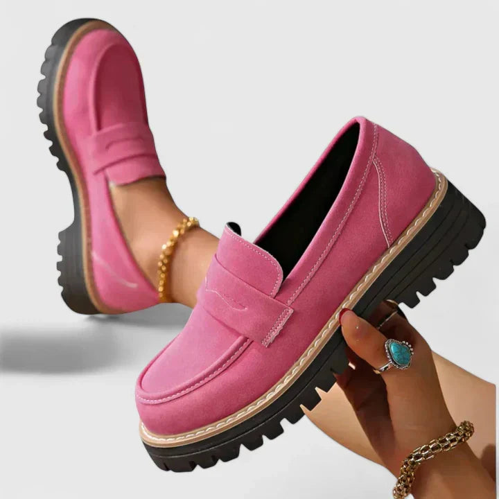 Black leather women's chunky lug-sole penny loafers. Durable platform slip-on shoes for versatile casual wear.