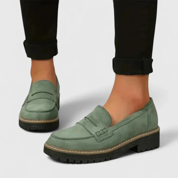 Versatile women's black chunky penny loafers with a lug-sole. Stylish platform slip-on shoes for casual or preppy outfits.