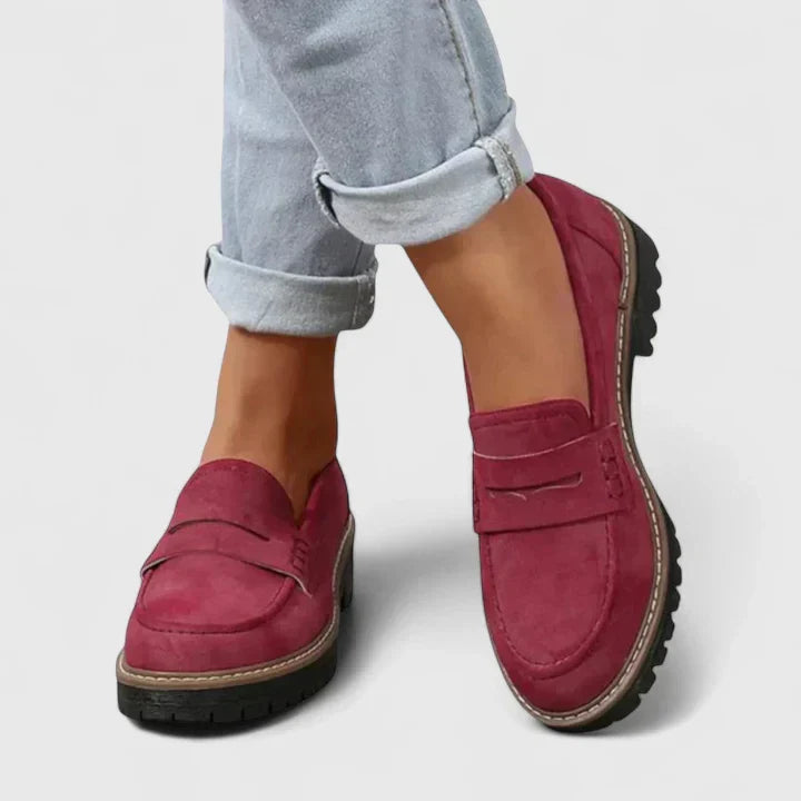 Classic black women's chunky penny loafers. Features a comfortable lug-sole and stylish platform, ideal for preppy fashion.