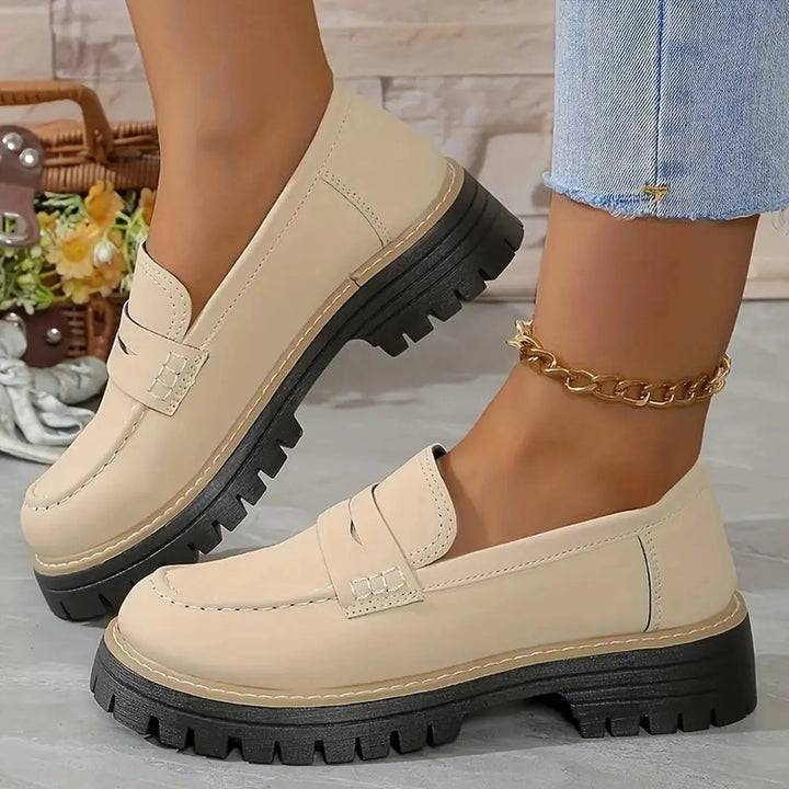 Women's black chunky platform loafers with a comfortable slip-on design and modern round toe.