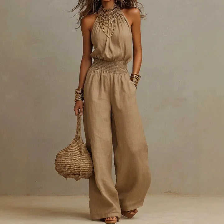 Chic white halter neck wide leg women's jumpsuit with a flattering smocked waist. Effortless elegant resort wear.