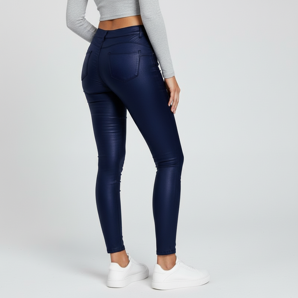 Woman posing in comfortable high-waisted skinny faux leather trousers, side view.