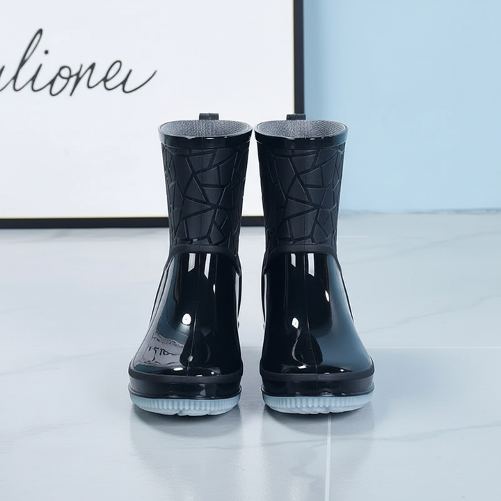 Close-up of women's mid-calf rain boot showing waterproof material and anti-slip sole detail
