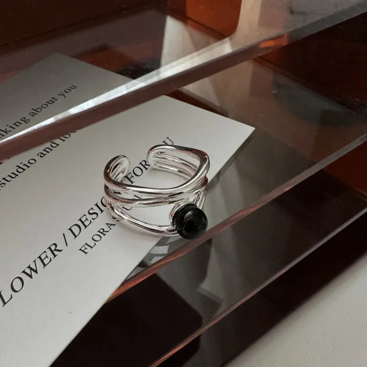 Sterling silver multi-line ring featuring a striking black onyx gemstone, elegant women's jewelry.