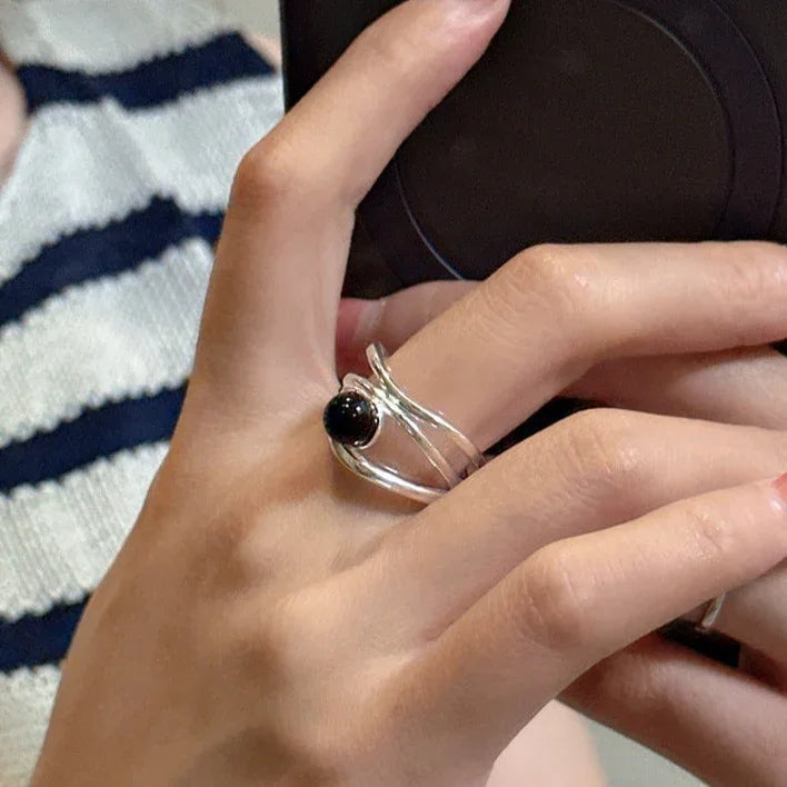 Fashionable women's multi-line ring with black onyx, crafted in gleaming sterling silver.