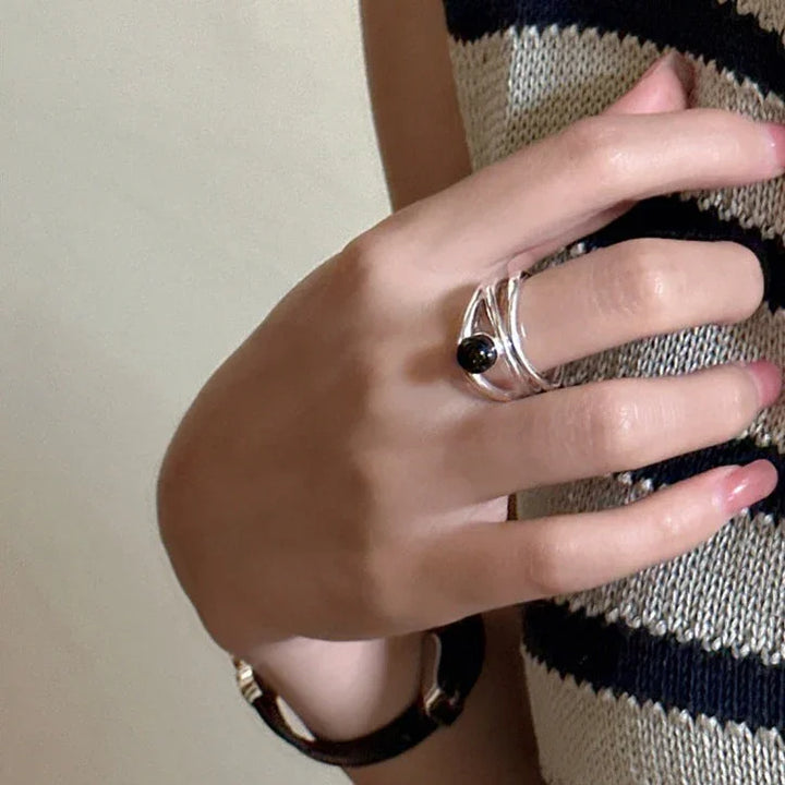 Close-up of an elegant women's black onyx multi-line sterling silver ring, a unique statement piece.