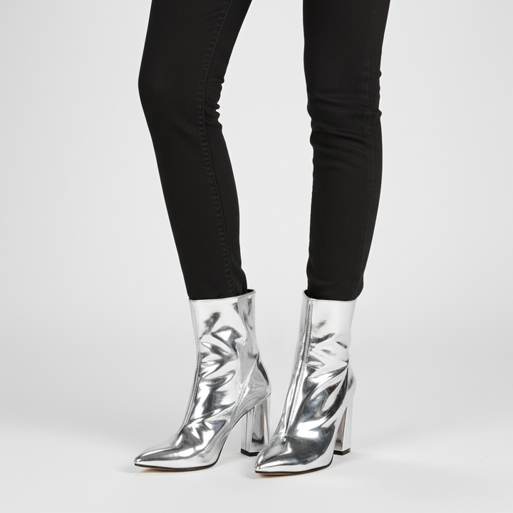 Detailed shot of the block heel and patent leather finish on women's chic autumn winter ankle boots with side zip.