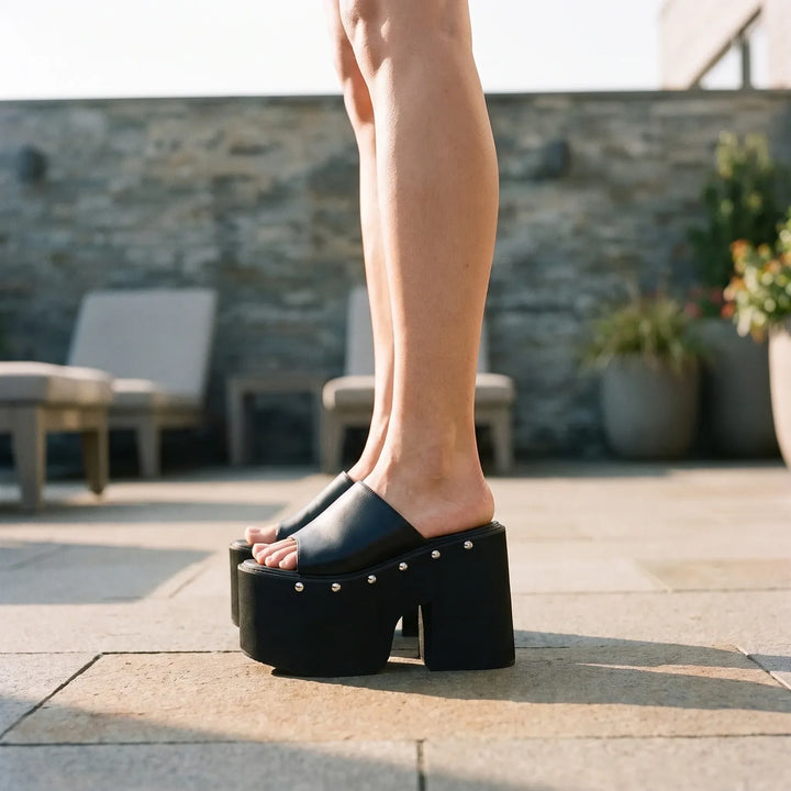 Women's black platform sandals with dramatic chunky block heel. Stylish open-toe summer fashion footwear.