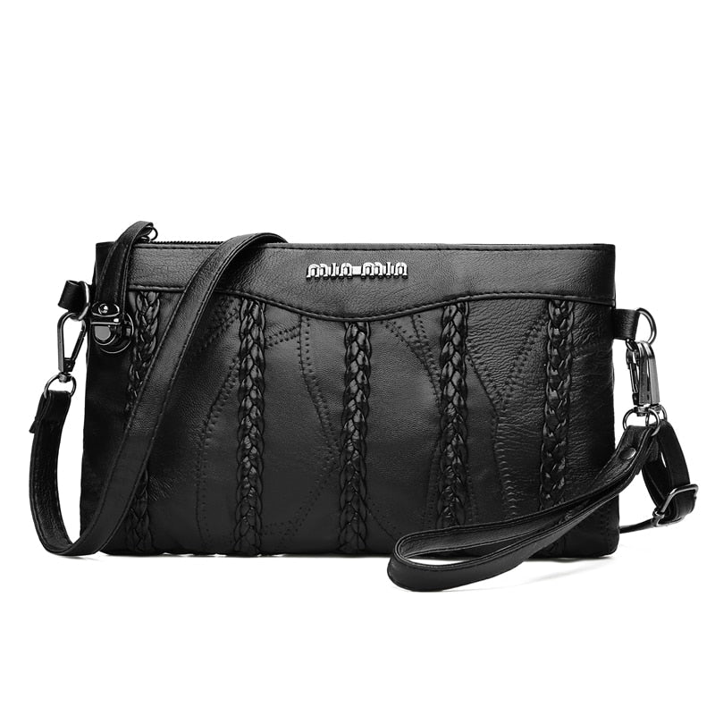 Women's black PU leather crossbody clutch bag with spacious interior, front view with flap closed