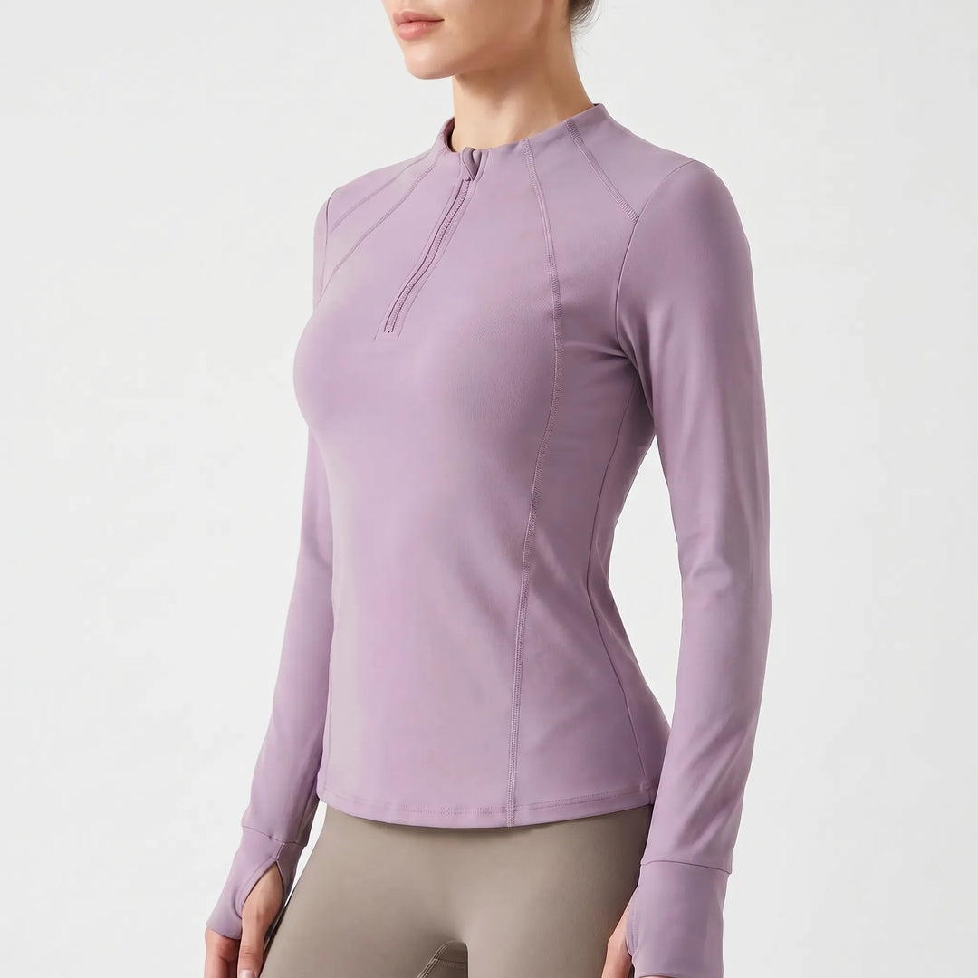 Woman running in a black long-sleeve quarter-zip performance top, perfect athletic wear for outdoor fitness.