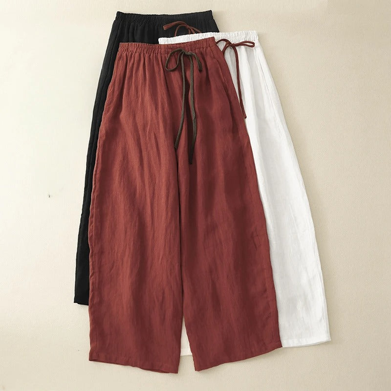 Relaxed fit black women's flowy pants with wide leg & gathered waist. Ideal for comfortable casual wear & summer fashion.