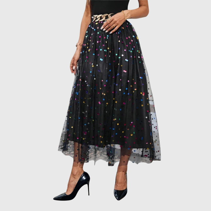 Sparkling black sequin high-waist midi skirt featuring a chic tulle overlay & asymmetric hem. Ideal for parties.
